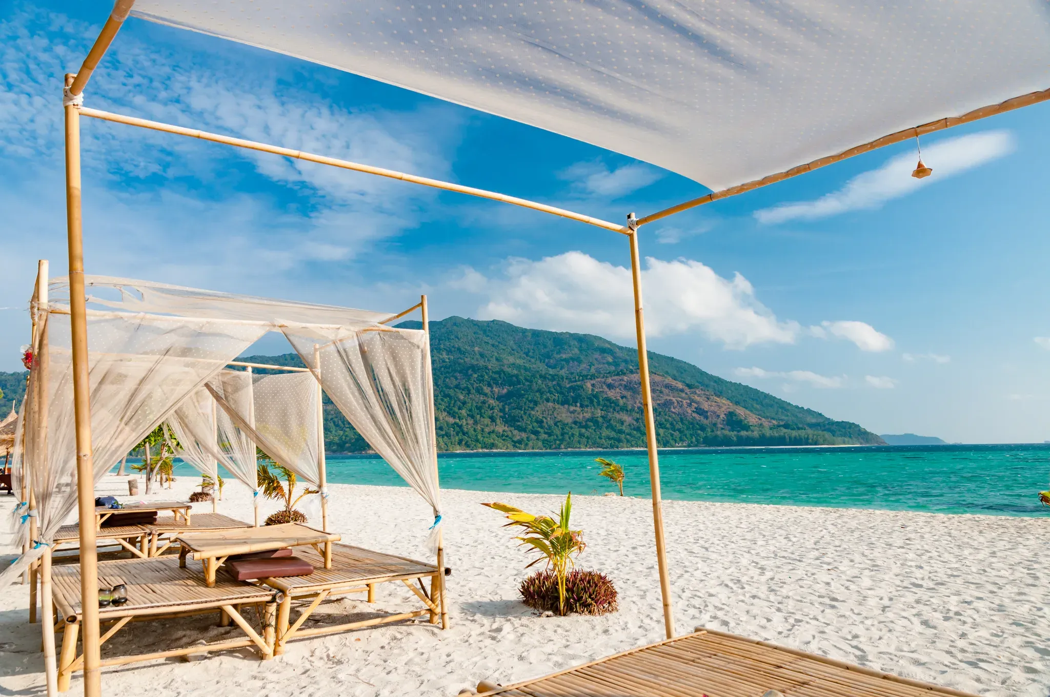 A shaded daybed cabana on a white-sand Phuket beach